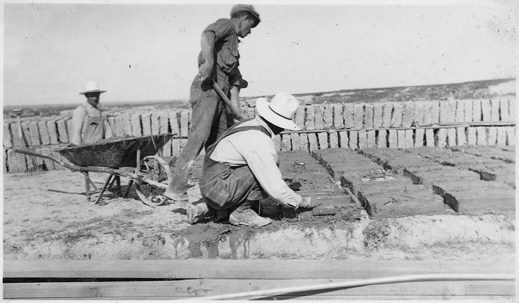 Photograph of adobe blocks being made in wood molds and dried in the sun by the worker.
Source: National Archives and Records Administration, 1935.